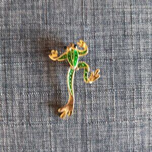 Green and gold colored frog brooch with moveable legs